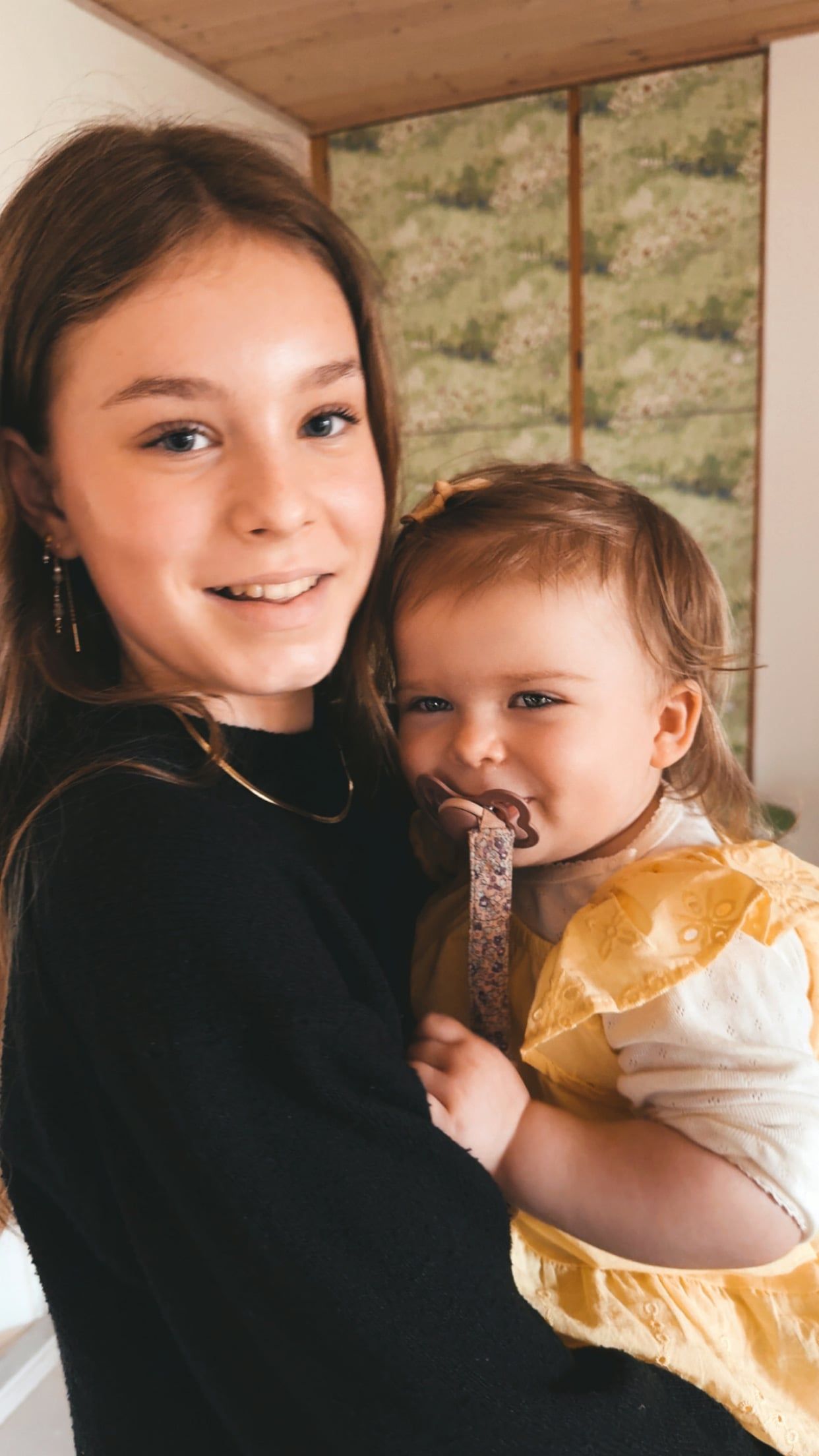 Naja holder en lille pige i gul kjole